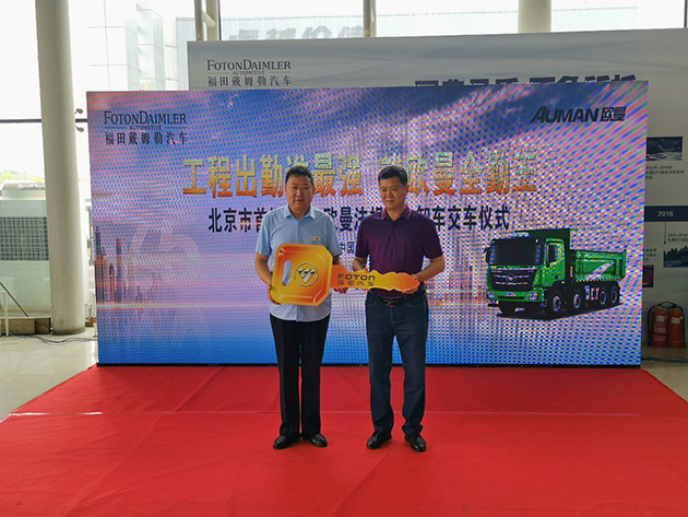 北京银汉华星总经理杨建斌（左）为客户代表颁发交车钥匙